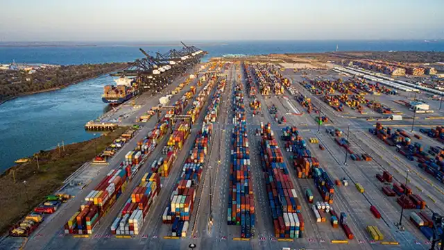 Aerial view of stacked shipping containers stored at Port Houston marine terminal awaiting pickup.